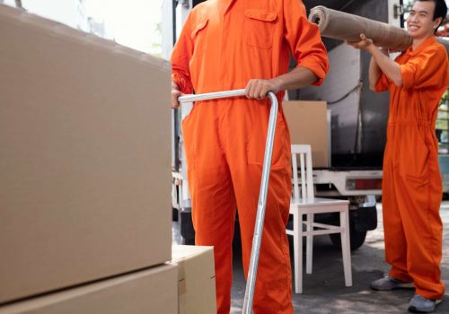 young-delivery-men-moving-objects-out-car